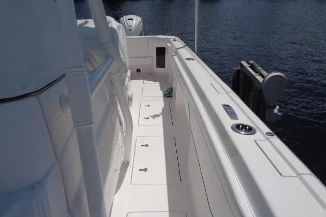 Slide: The Image of 2020 Intrepid 345 Nomad FE boat deck, white interior, docked by water. - 11