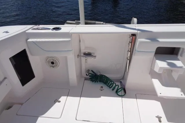 Slide: The Image of 2020 Intrepid 345 Nomad FE boat deck with storage compartments and coiled hose. - 16