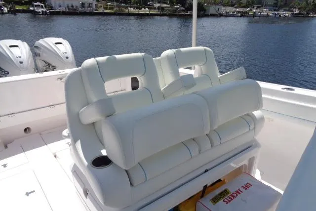 Slide: The Image of 2020 Intrepid 345 Nomad FE boat with white cushioned seating and dual outboard motors. - 21