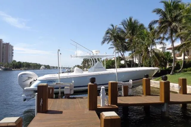 Slide: The Image of 2020 Intrepid 345 Nomad FE docked by palm trees and waterfront homes. - 5