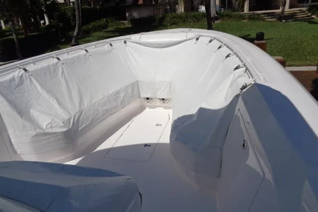 Slide: The Image of 2020 Intrepid 345 Nomad FE boat interior with protective cover, showcasing spacious seating area. - 7