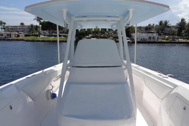 Slide: The Image of 2020 Intrepid 345 Nomad FE boat with spacious deck and seating, docked by waterfront homes. - 8