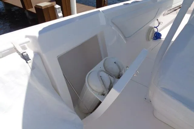 Slide: The Image of 2020 Intrepid 345 Nomad FE boat interior with storage compartment and white seating. - 9