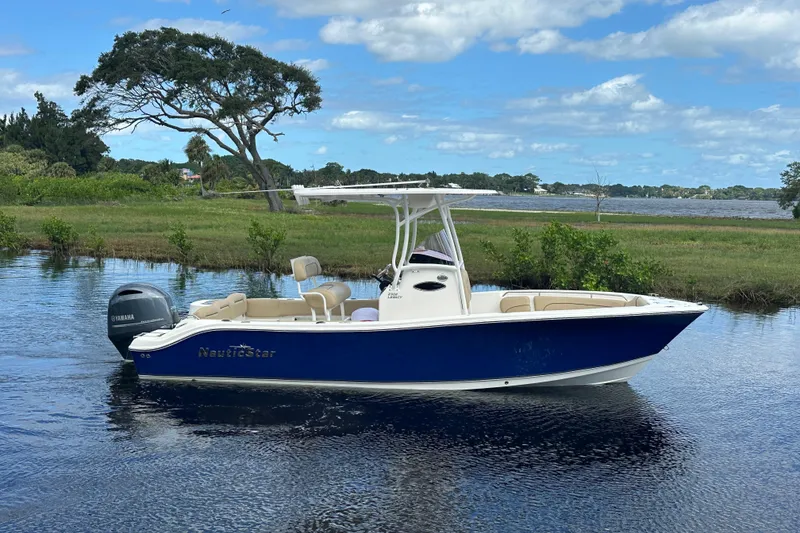 The Image of 2019 NauticStar 2302 Legacy boat on calm water, scenic background. - 0