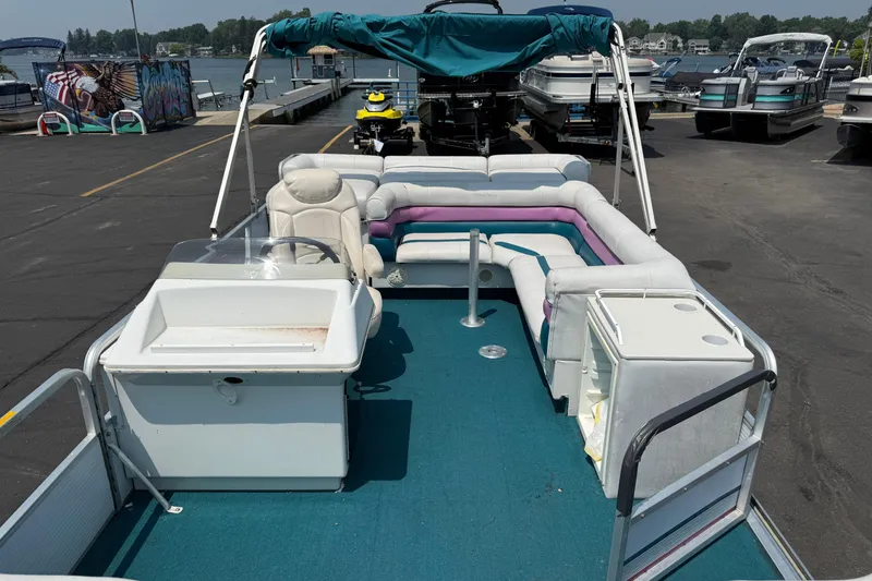Slide: The Image of 1995 AquaPatio 24 pontoon boat with seating, canopy, and docked at marina. - 10