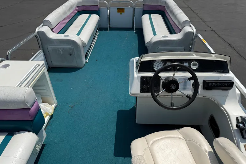 Slide: The Image of 1995 AquaPatio 24 pontoon boat interior with blue carpet and white seating. - 14