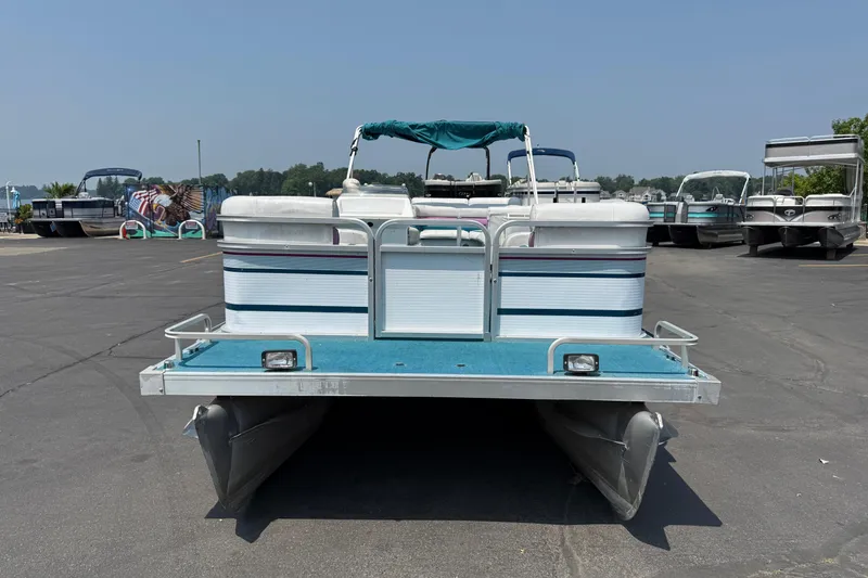 Slide: The Image of 1995 AquaPatio 24 pontoon boat in a parking lot, rear view. - 2