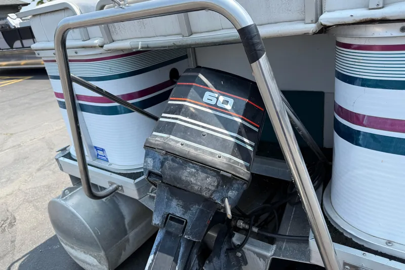 Slide: The Image of 1995 AquaPatio 24 boat with a 60 HP outboard motor, docked on pavement. - 5