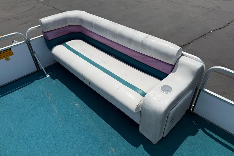 Slide: The Image of White and teal seating on 1995 AquaPatio 24 boat with blue carpet flooring. - 8
