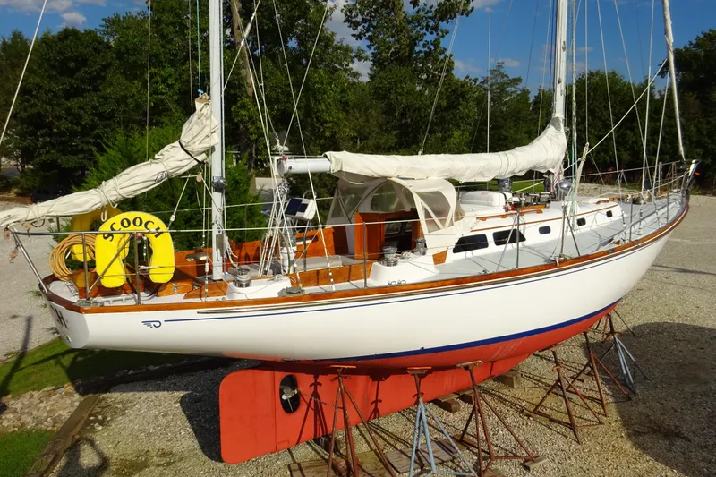 Slide: The Image of 1970 Hinckley Bermuda 40 Custom sailboat on stands, with white hull and wooden deck. - 2