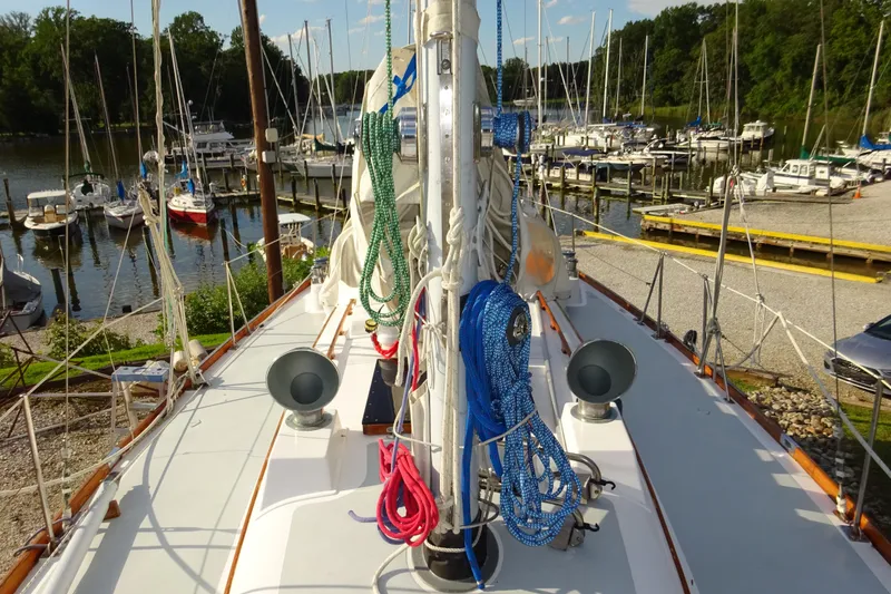 Slide: The Image of Hinckley Bermuda 40 Custom sailboat deck, 1970 model, docked at a marina with surrounding boats. - 20