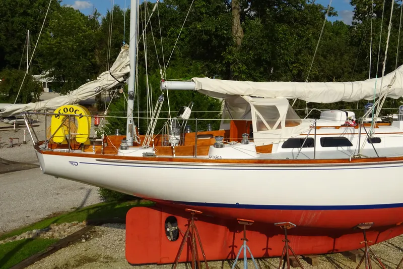 Slide: The Image of 1970 Hinckley Bermuda 40 Custom sailboat on land, with white hull and wooden deck. - 3
