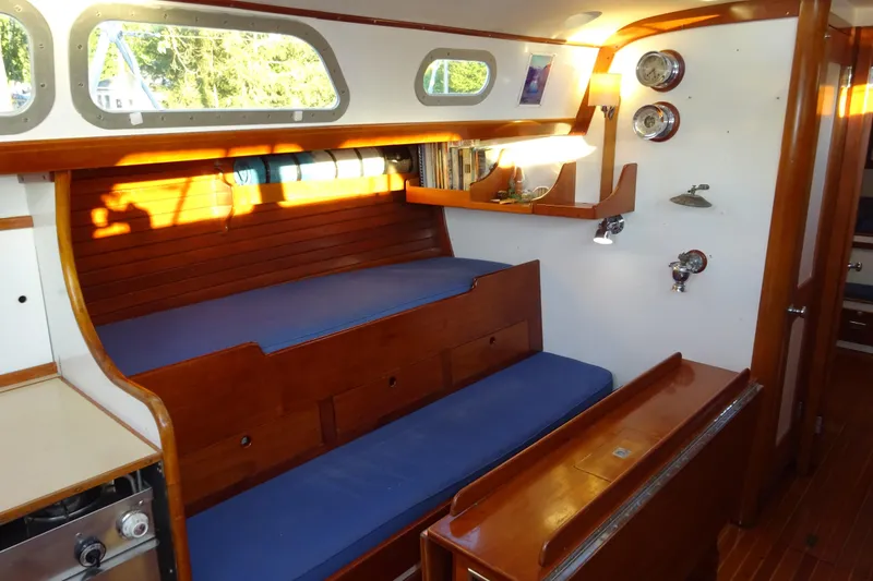 Slide: The Image of Interior of 1970 Hinckley Bermuda 40 Custom sailboat with wooden furnishings and blue cushions. - 47