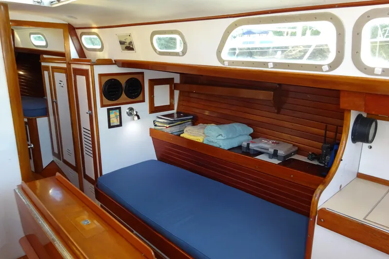 Slide: The Image of Interior of 1970 Hinckley Bermuda 40 Custom sailboat with wooden furnishings and blue cushions. - 50