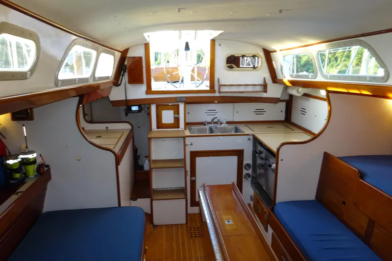 Slide: The Image of Interior of 1970 Hinckley Bermuda 40 Custom sailboat with cozy wooden furnishings and compact kitchen. - 51