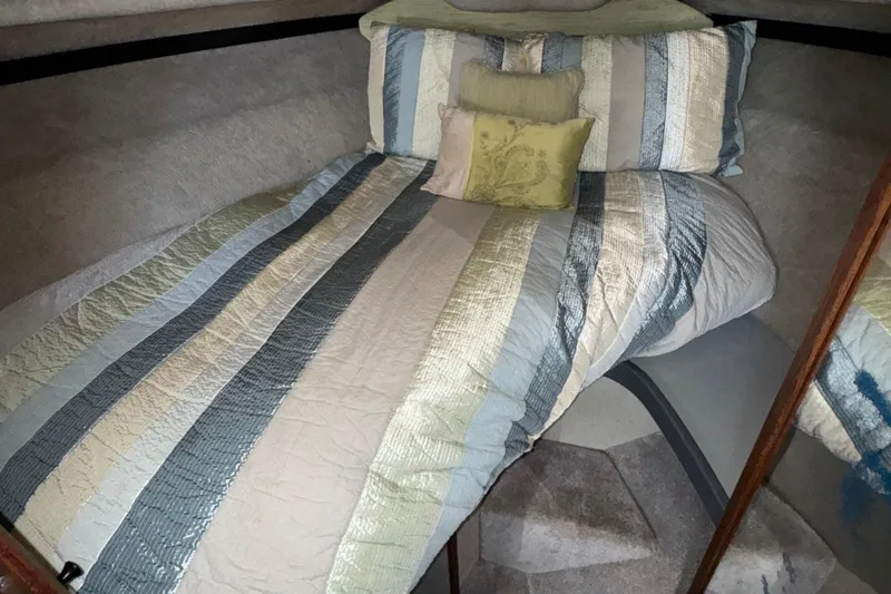 Slide: The Image of Cozy cabin interior of 1985 Formula 28 PC boat with striped bedding. - 11