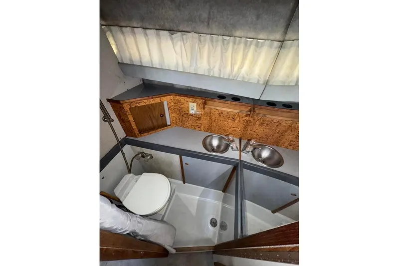 Slide: The Image of 1985 Formula 28 PC boat bathroom with dual sinks, wooden cabinetry, and compact shower. - 12