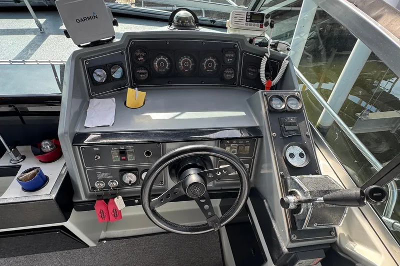 Slide: The Image of 1985 Formula 28 PC boat dashboard with steering wheel, gauges, and Garmin device. - 5