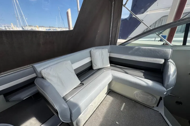 Slide: The Image of 1985 Formula 28 PC boat interior with gray seating and cushions, docked at marina. - 7