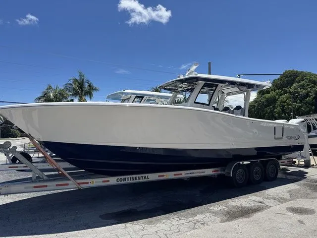 The Image of 2026 Robalo R360 Center Console boat on trailer under clear blue sky. - 1