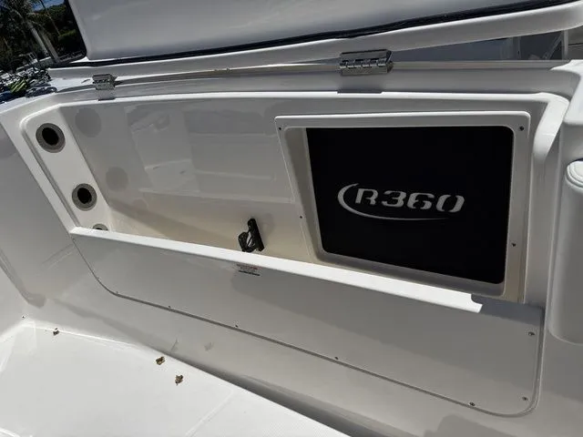 Slide: The Image of 2026 Robalo R360 Center Console boat interior detail with storage compartment. - 25
