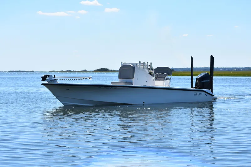 Slide: The Image of 2023 Xplor X24 boat on calm water under clear blue sky. - 1