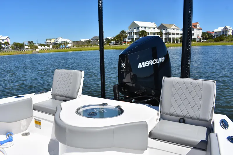 Slide: The Image of 2023 Xplor X24 boat with gray seating, on calm water under clear blue sky. - 12