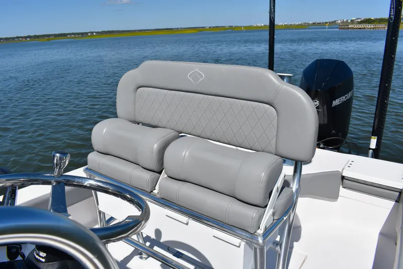 Slide: The Image of 2023 Xplor X24 boat with Mercury engine on calm water, near waterfront homes. - 15