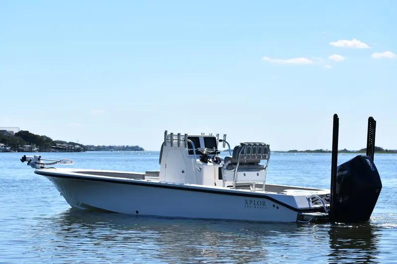 Slide: The Image of 2023 Xplor X24 boat cruising on calm blue waters under clear sky. - 2