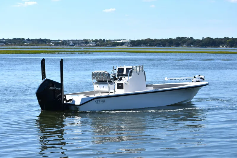 Slide: The Image of 2023 Xplor X24 boat on calm water, featuring a sleek design and Mercury engine. - 5