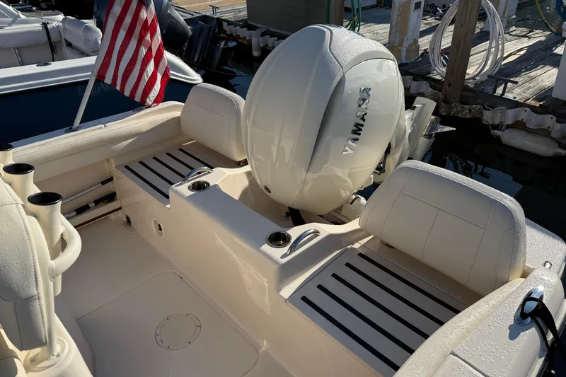 Slide: The Image of 2024 Grady-White Fisherman 216 boat docked in a marina, featuring an American flag. - 4