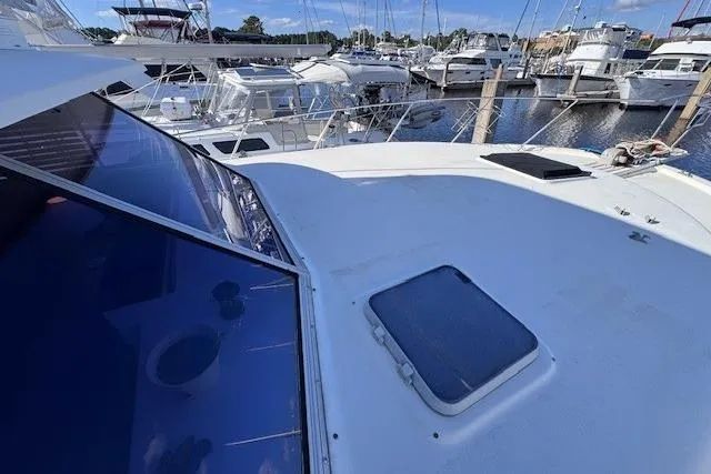 Slide: The Image of 1985 Silverton 40 ACMY yacht docked in a marina, surrounded by other boats. - 10