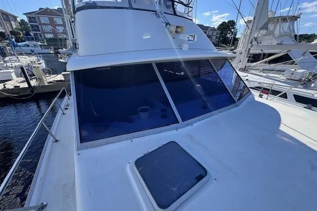 Slide: The Image of 1985 Silverton 40 ACMY yacht docked at marina, showcasing sleek design and spacious deck. - 13