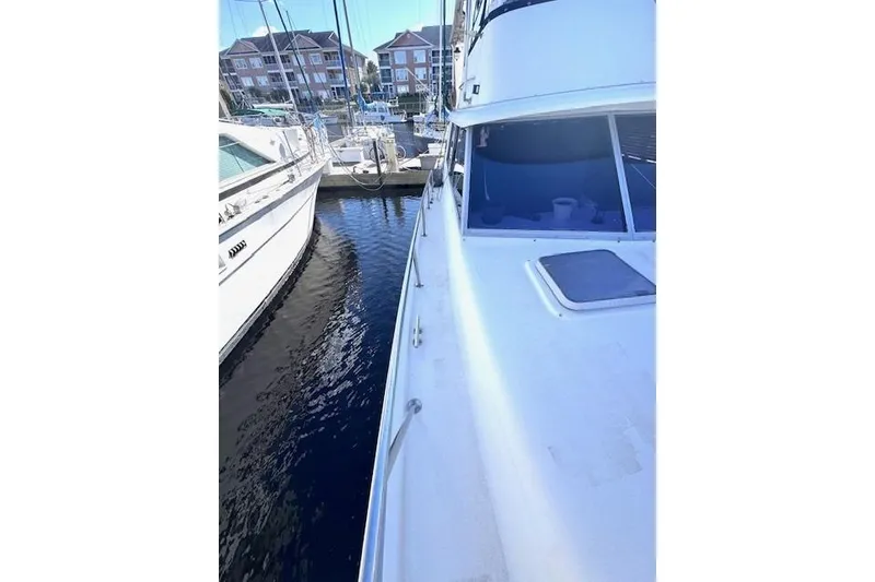Slide: The Image of 1985 Silverton 40 ACMY yacht docked at marina, side view with water reflection. - 15