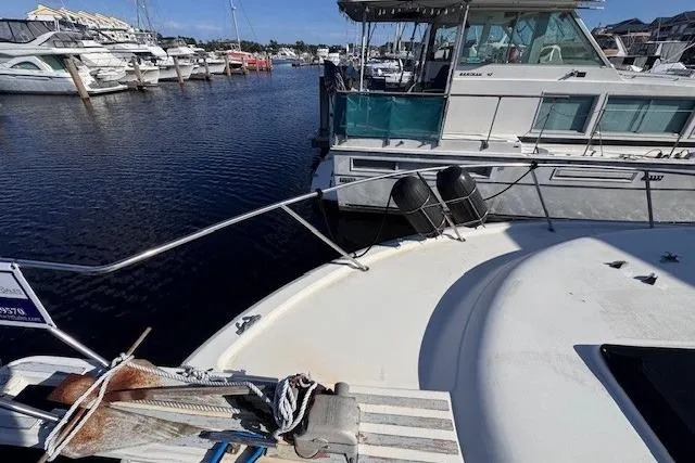 Slide: The Image of 1985 Silverton 40 ACMY yacht docked in a marina with other boats. - 16