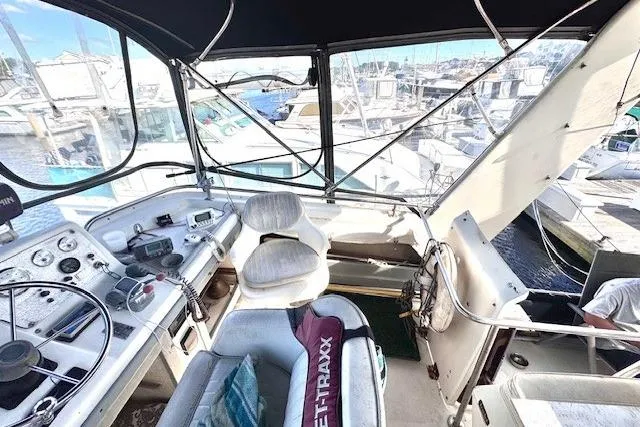 Slide: The Image of 1985 Silverton 40 ACMY yacht cockpit with steering wheel, controls, and marina view. - 18