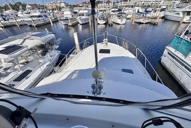 Slide: The Image of 1985 Silverton 40 ACMY yacht docked in a marina, surrounded by other boats. - 19