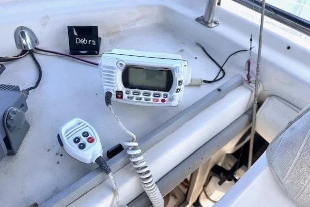 Slide: The Image of 1985 Silverton 40 ACMY boat interior with marine radio and microphone on dashboard. - 26