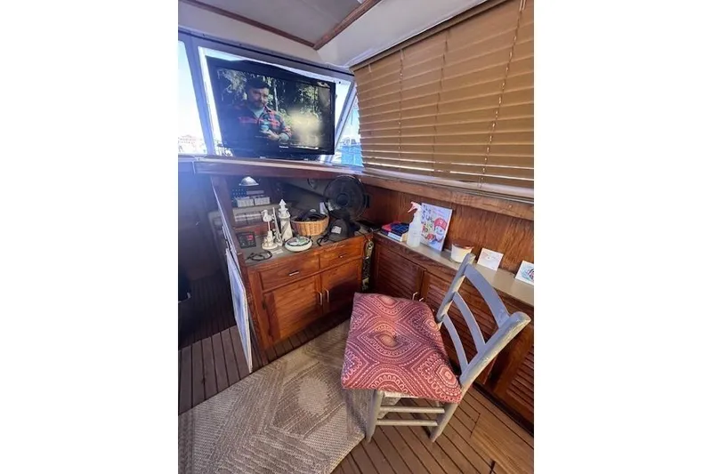 Slide: The Image of Interior of 1985 Silverton 40 ACMY yacht with TV, wooden cabinets, and chair. - 36