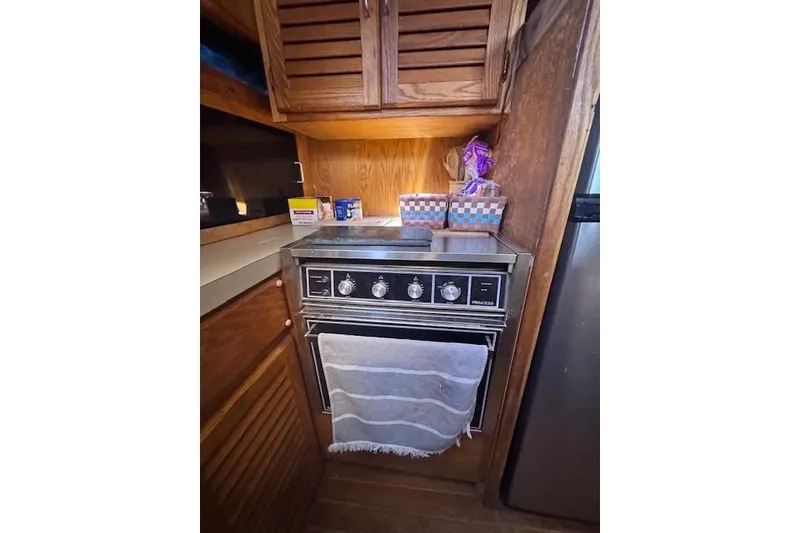 Slide: The Image of 1985 Silverton 40 ACMY yacht kitchen with vintage stove and wooden cabinetry. - 38