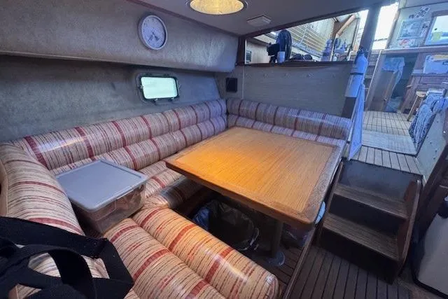 Slide: The Image of 1985 Silverton 40 ACMY interior with striped seating, wooden table, and nautical decor. - 45