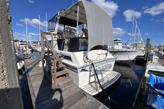 Slide: The Image of 1985 Silverton 40 ACMY yacht docked at marina under clear blue sky. - 5