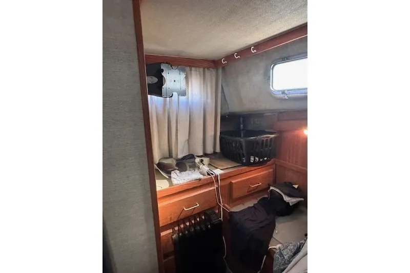 Slide: The Image of 1985 Silverton 40 ACMY cabin interior with wooden cabinetry and window. - 50