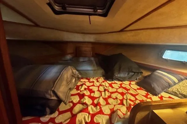 Slide: The Image of Cozy cabin interior of 1985 Silverton 40 ACMY with heart-patterned bedding. - 55