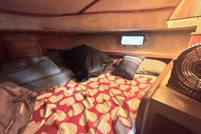 Slide: The Image of Cozy cabin interior of 1985 Silverton 40 ACMY with heart-patterned bedding and small window. - 56