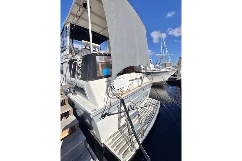Slide: The Image of 1985 Silverton 40 ACMY yacht docked under clear blue sky. - 6
