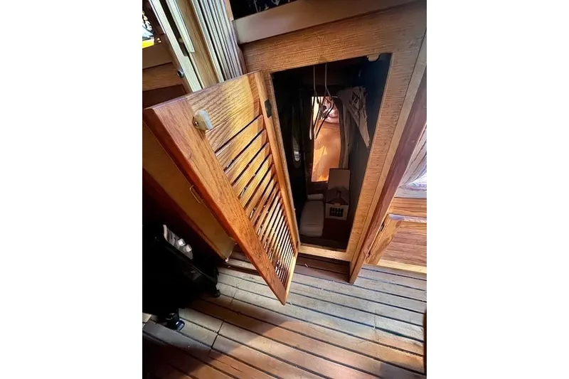 Slide: The Image of 1985 Silverton 40 ACMY interior with open wooden cabinet door, revealing storage space. - 60