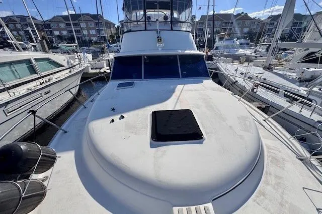 Slide: The Image of 1985 Silverton 40 ACMY yacht docked in a marina, surrounded by other boats. - 7