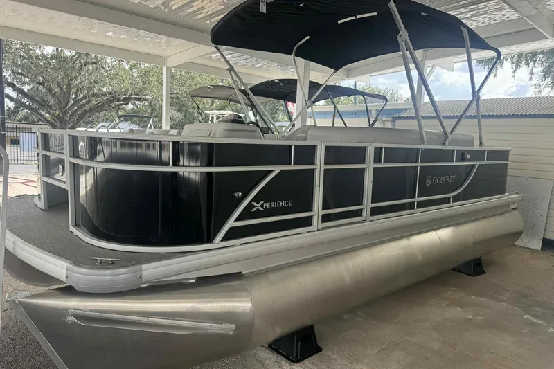 Slide: The Image of 2026 Sweetwater 2086FX pontoon boat with sleek black design under a covered area. - 1