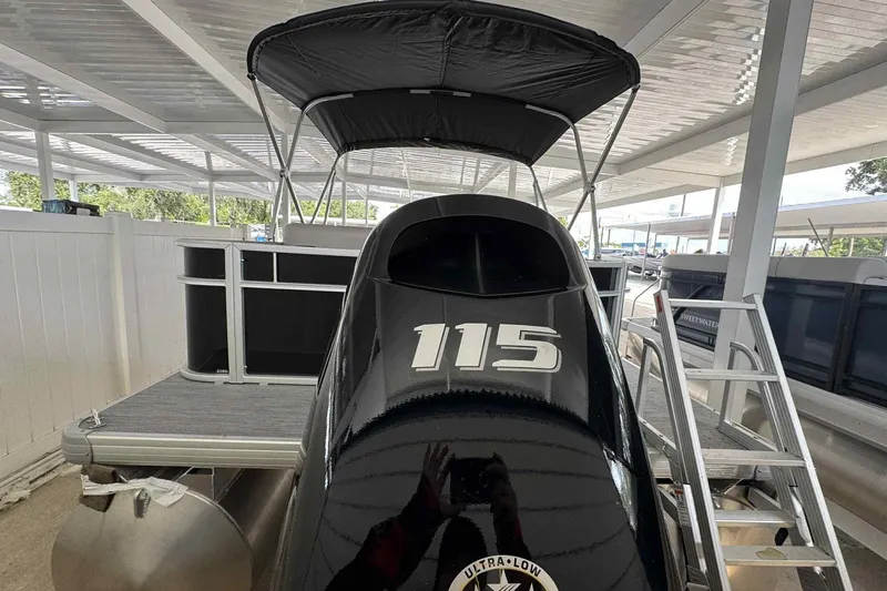 Slide: The Image of 2026 Sweetwater 2086FX pontoon boat with 115 horsepower engine, docked under shelter. - 10